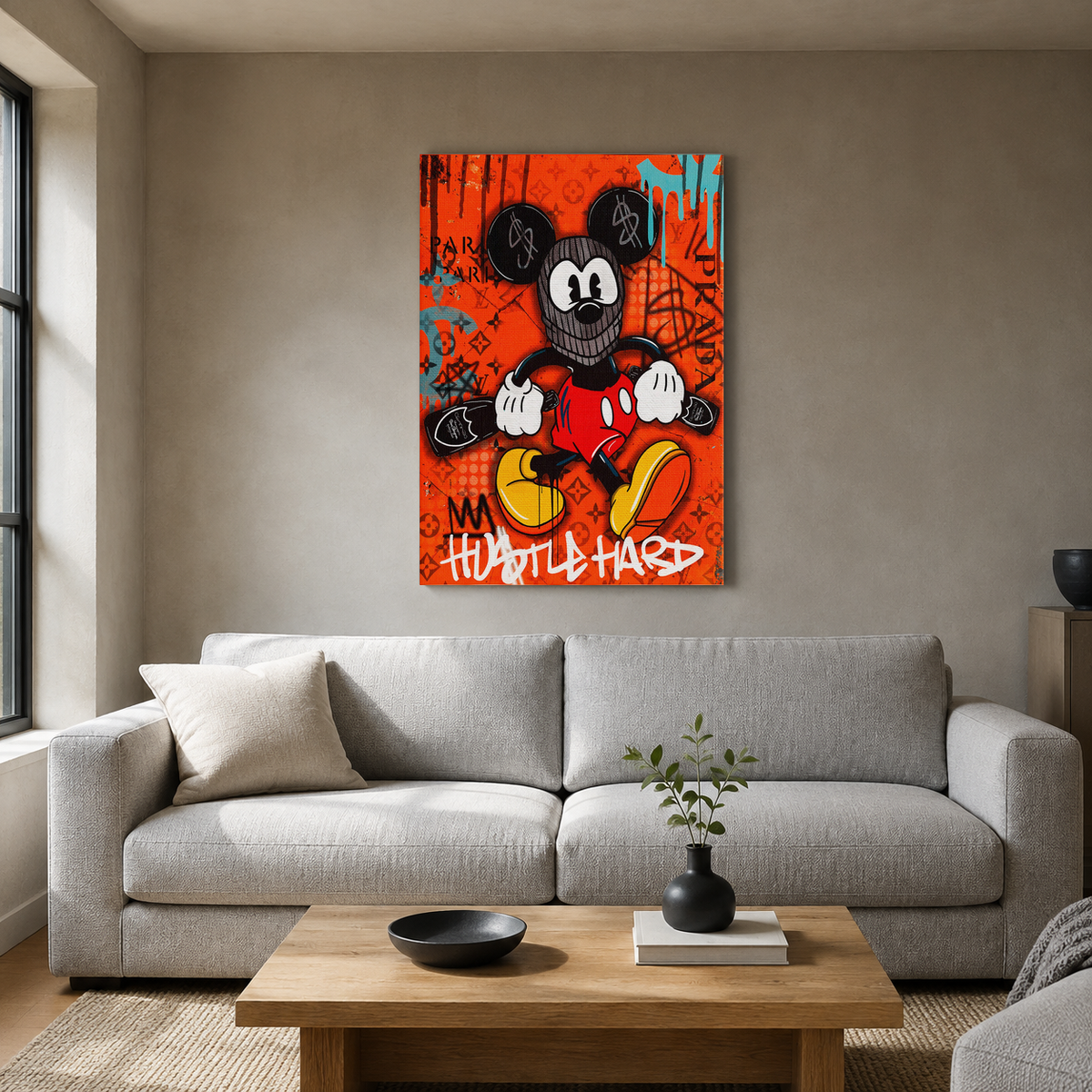 Πορτοκαλί pop-art πίνακας Mickey Mouse «Hustle Hard» σε απλό μοντέρνο σαλόνι με γκρι καναπέ.
